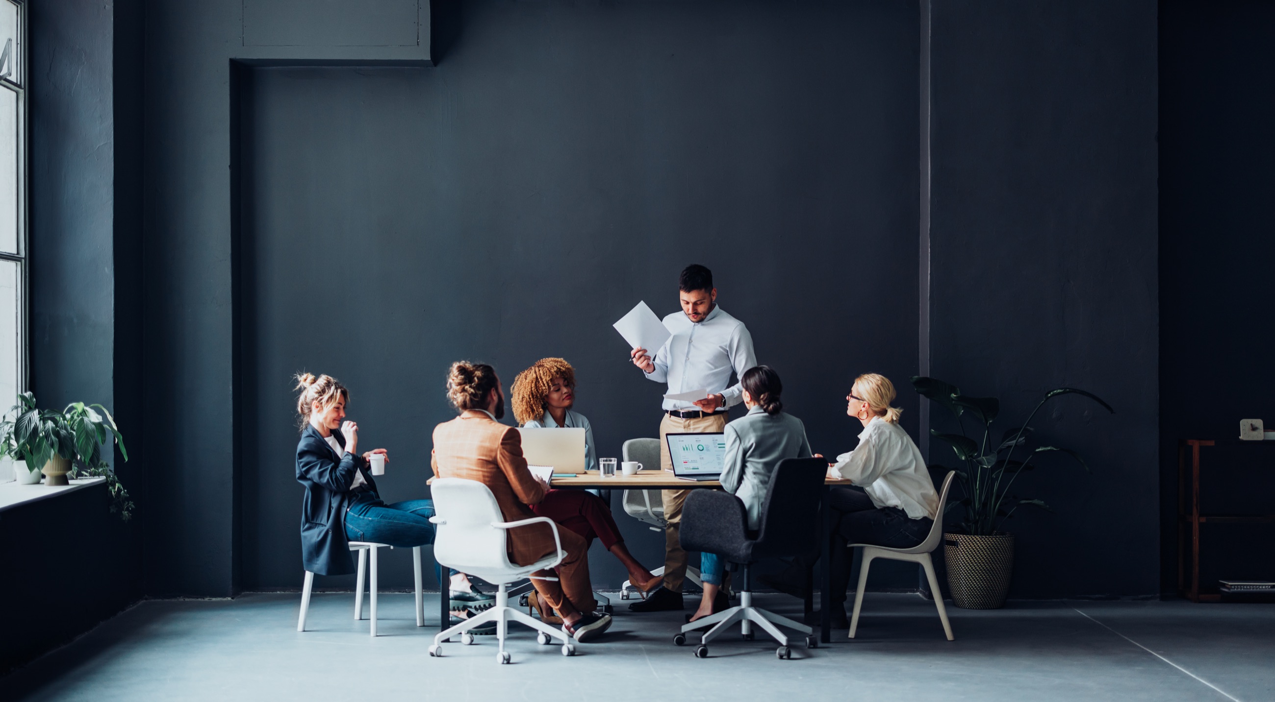 A diverse working team gathered around a table to review information and coordinate decisions