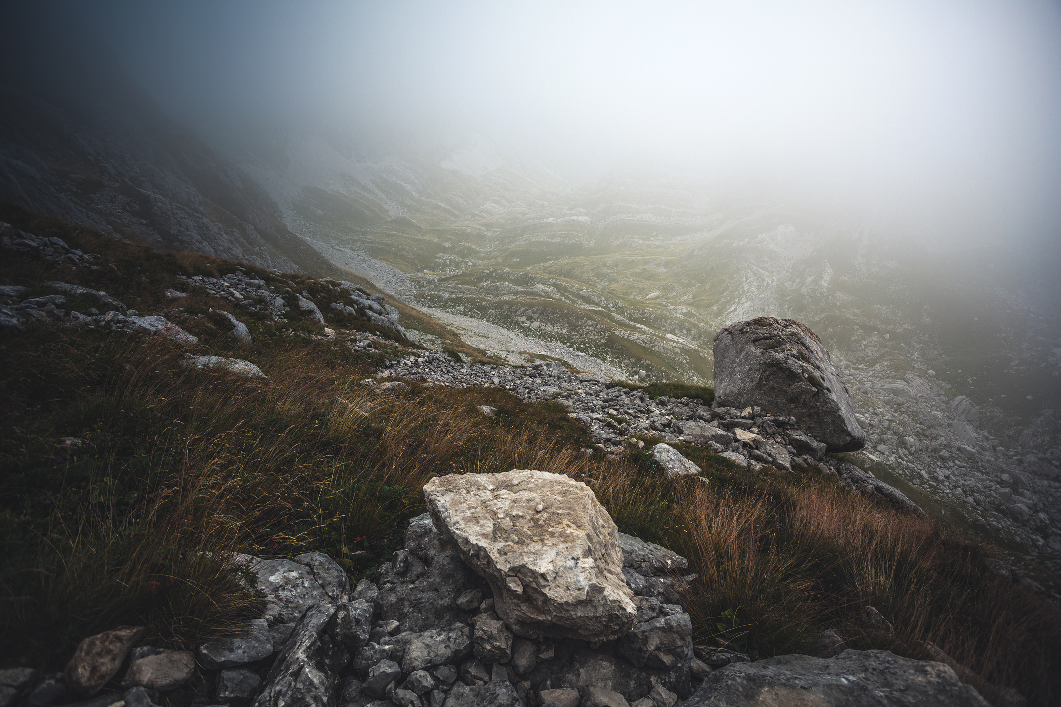 A fog-covered rocky landscape with a route opening through the terrain